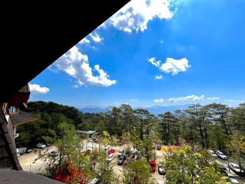 uma vista para um parque com um céu azul em The Forest Lodge at Camp John Hay privately owned unit with parking 545 em Baguio
