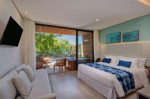 um quarto com uma cama grande e uma sala de estar em Wyndham Ilhabela Casa Di Sirena em Ilhabela