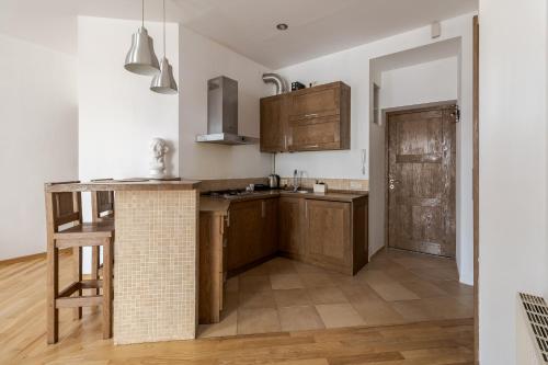 a kitchen with wooden cabinets and a counter top at Rynok Square apartment with balcony in Lviv