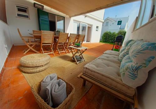 a living room with a couch and a table and chairs at Beach House in São Martinho do Porto