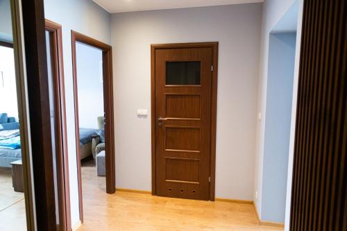 a room with a wooden door and a bedroom at Apartament Rynek 10 in Ostrowiec Świętokrzyski