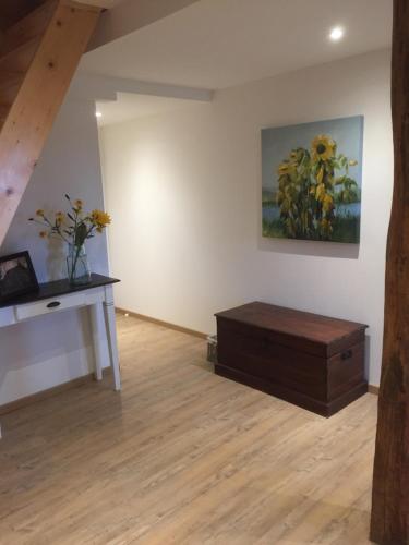 a room with a table and a painting on the wall at Unter Eichen in Uplengen