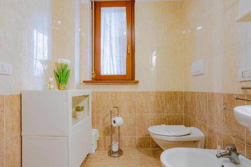 La salle de bains est pourvue d'un lavabo, de toilettes et d'une fenêtre. dans l'établissement HOME SWEET HOME, à Acilia