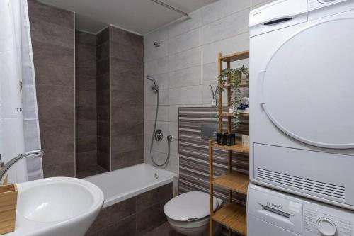 La salle de bains est pourvue d'un lavabo, de toilettes et d'une baignoire. dans l'établissement Yefeh Nof - City Center 2BR Apartment, à Jérusalem