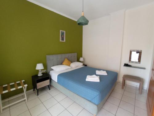 a bedroom with a blue bed and green walls at Tasos Seagull apartments in Chania