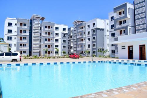 a large swimming pool in front of some apartment buildings at Siloam Apartments in Mombasa