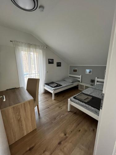 a room with two beds and a desk in it at HausGregor, Messe 15 min, City 20 min und Erholung im Grünen in Winkelhaid