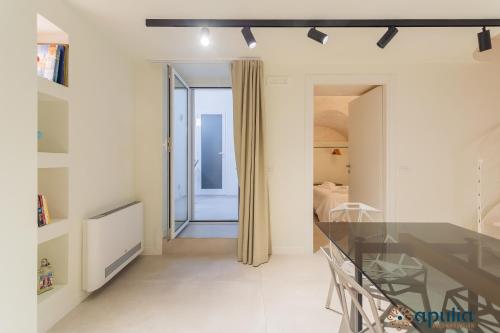 a living room with a glass table and a bedroom at Zema Home by Apulia Accommodation in Bari