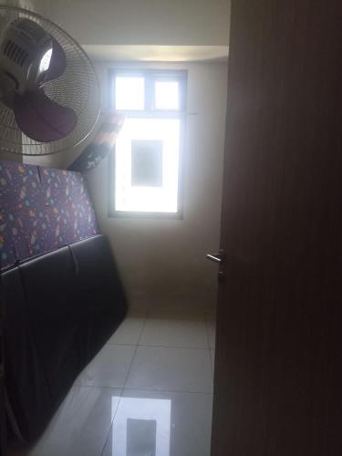 a room with a window and a door with a fan at Kens home in Jakarta