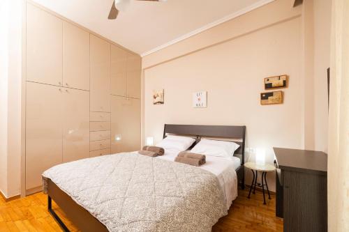 a white bedroom with a bed and a desk at Four Reasons Apts Ntepo in Thessaloniki