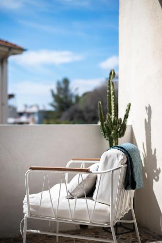 une chaise blanche assise sur un balcon avec un cactus dans l'établissement Le George V - Art de Vivre à la Niçoise, à Nice