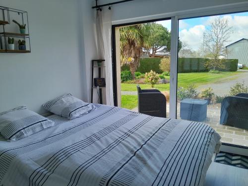 ein Schlafzimmer mit einem Bett und einem großen Fenster in der Unterkunft Chez Maryline in Chalonnes-sur-Loire