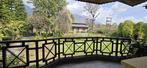 a iron fence with a view of a garden at Blossoms Village Resort in Dharamshala