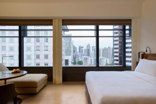 a hotel room with a bed and a large window at COMO Metropolitan Singapore in Singapore
