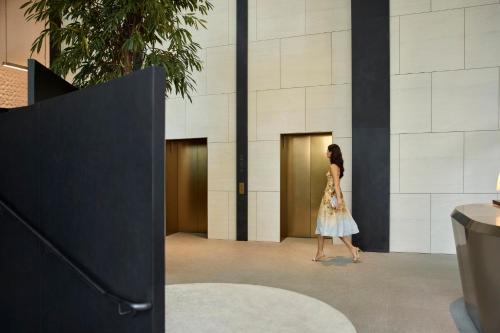 a woman walking in front of a building at COMO Metropolitan Singapore in Singapore