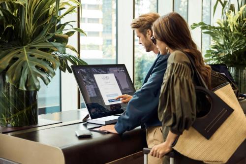 two people sitting at a table with a laptop at COMO Metropolitan Singapore in Singapore
