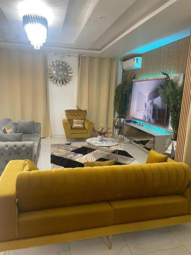 a living room with a yellow couch and a flat screen tv at VEGAS APERTMENT in Amdalai
