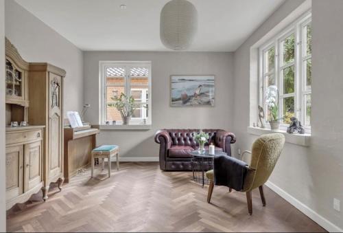 a living room with a couch and a table at Nyere villa nær by, skov, strand in Højbjerg