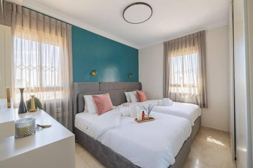 ein Schlafzimmer mit einem großen weißen Bett und einer blauen Wand in der Unterkunft City Lights 4 BR Stunning Apart in Jerusalem