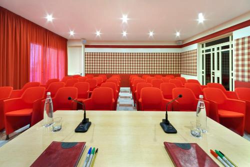 a conference room with red chairs and a wooden table at Hotel Continental in Sorrento