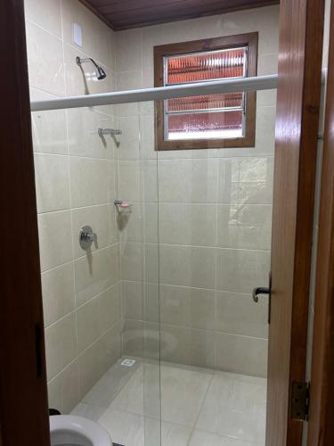 ドミンゴス・マルチンスにあるChalé Essência do Valeのガラス張りのシャワーとトイレ付きのバスルーム