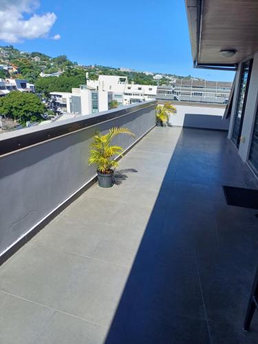a balcony with potted plants on a building at Roof Top Papeete in Papeete
