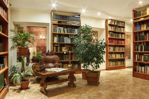 a library with bookshelves and a couch and a table at Felisa Hotel in Kharkiv