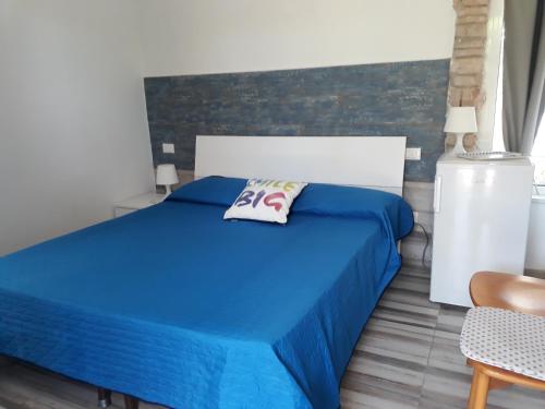 a bedroom with a blue bed with a pillow on it at Bellavista in Torre dell'Orso
