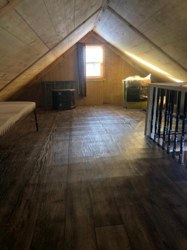 an attic room with a bed and a window at Camp Rhino in Remsen