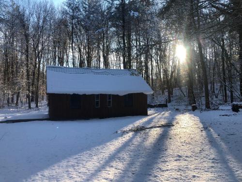 a barn in the snow with the sun in the background at Camp Rhino in Remsen