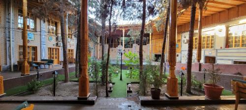 an empty courtyard with trees in a building at Hotel Kamila in Samarkand