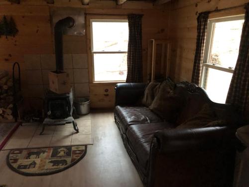 a living room with a couch and a wood stove at Camp Rhino in Remsen