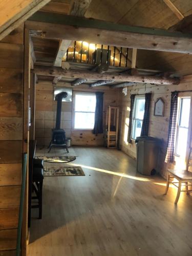 an empty room with a stove in a cabin at Camp Rhino in Remsen