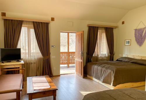 a bedroom with a bed and a tv and a window at Ecokayan Dilijan Resort Hotel in Dilijan
