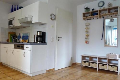 a kitchen with white cabinets and a table in it at NEU! Ferienwohnung Arkona auf Rügen in Putgarten