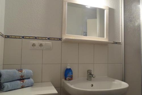 W łazience znajduje się umywalka i lustro. w obiekcie NEU! Ferienwohnung Arkona auf Rügen w mieście Putgarten