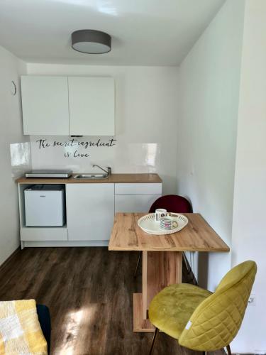 eine Küche mit einem Holztisch und Stühlen in der Unterkunft Rooms and apartments Vili in Ptuj
