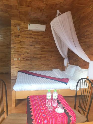 um quarto com uma cama e uma mesa com duas garrafas de água em Sau Meo Mountain View em Sapa