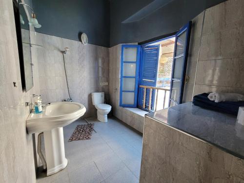 baño con lavabo y aseo y ventana en chez youssef, en Fez
