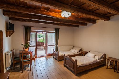 uma sala de estar com 2 camas e uma varanda em Zsirai Guest House em Mád