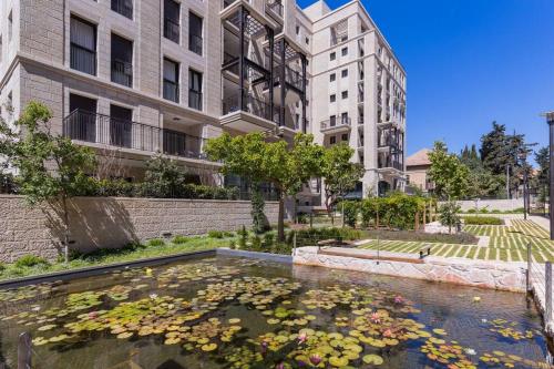 een vijver vol bloemen voor een gebouw bij Apartment in Jerusalem Estate in Jeruzalem