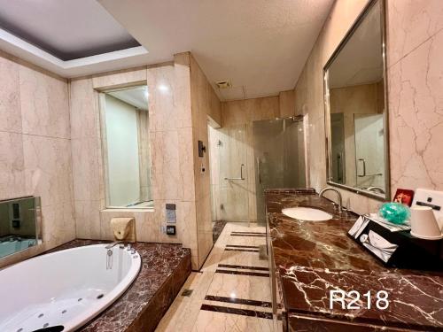 a large bathroom with a tub and a sink at Cigar Motel in Tainan