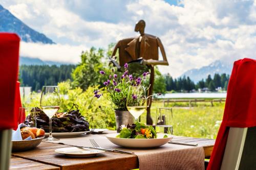 una mesa con comida y una estatua de un hombre en bicicleta en Hotel Seehof, en Valbella