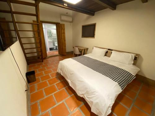 a bedroom with a large bed with white sheets at Sunshine Music Traditional Guesthouse in Jinsha