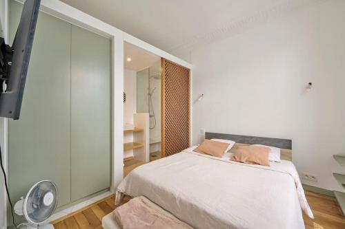 Habitación blanca con cama y espejo en Pause détente à Courbevoie, en Courbevoie