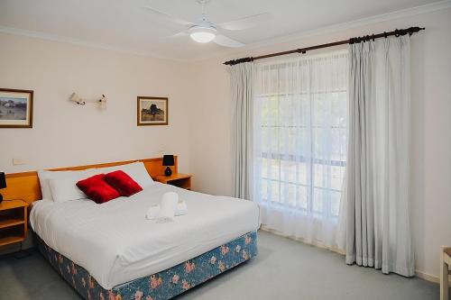 een slaapkamer met een bed en een groot raam bij Near Murray River - A Lovely Holiday Unit in Moama in Moama