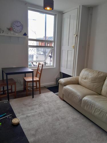 a living room with a couch and a table and a window at Bobi in Sheffield