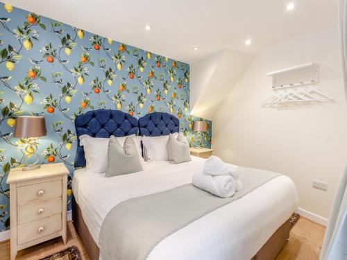 a bedroom with a large bed with a blue headboard at The Studio in Beckington