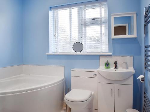 a bathroom with a white toilet and a sink at Lyncroft Holiday Bungalow in Sandbach