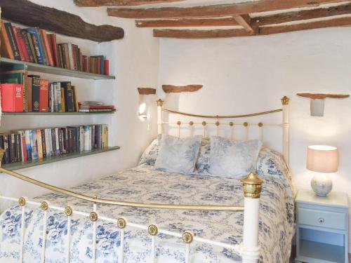 a bedroom with a bed and bookshelves at Brow House in Brigsteer
